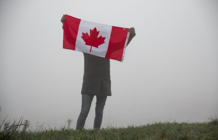 person holding flag of Canada