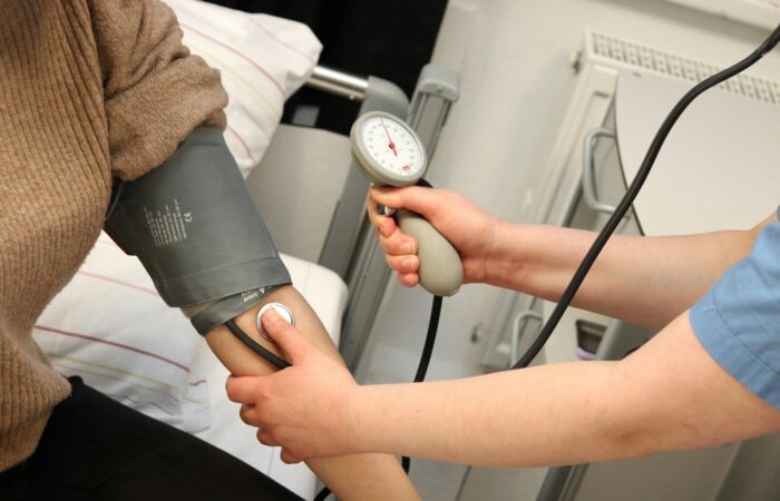 A person with a blood pressure device in their hand