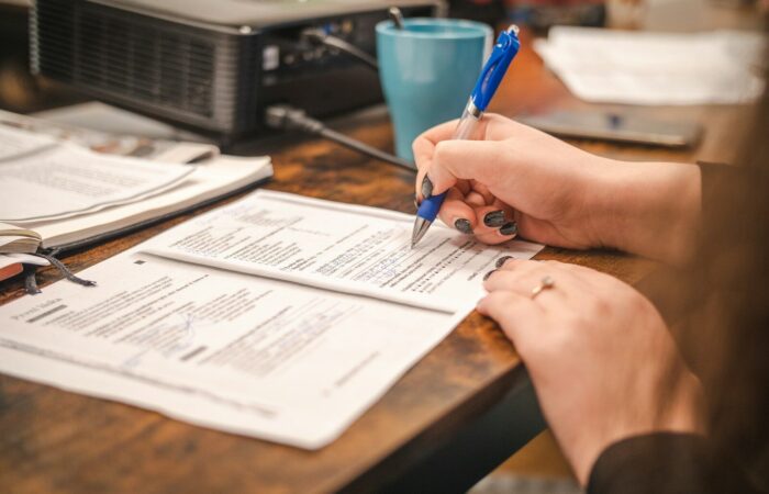 a woman sitting at a table with a pen and paper