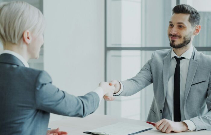 Two professionals shaking hands across a table